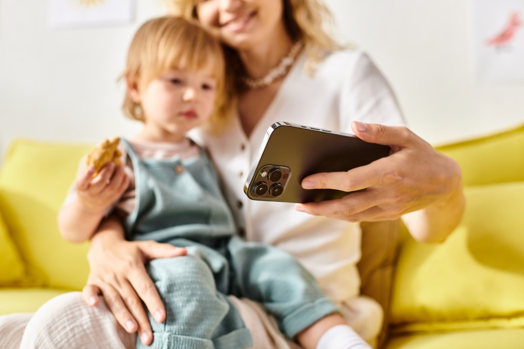 A mother allows her child to look at a smartphone.